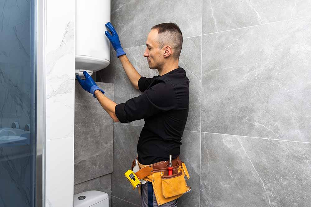 Bell Plumbing technician inspecting a water heater