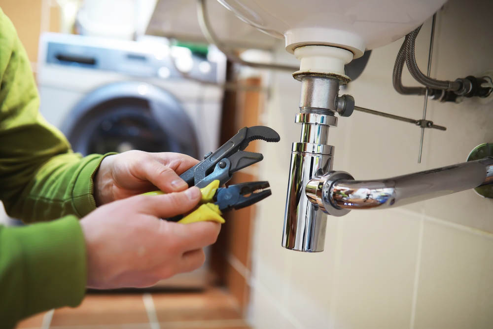 Bell Plumbing technician working on drain repairs